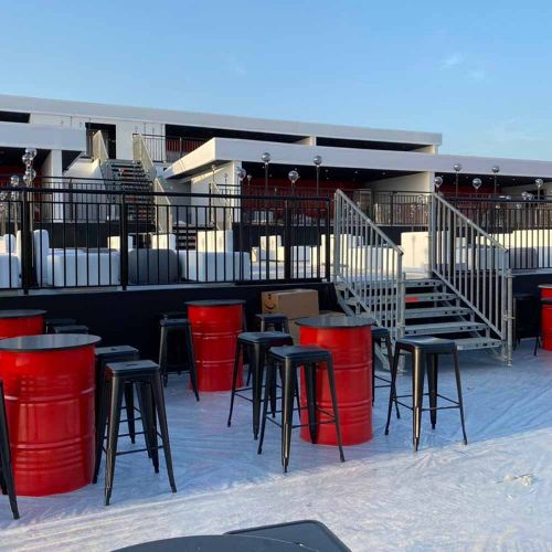 Event Venue Fabrication with Red Barrel Tables and Stools in Ras Al Khaimah